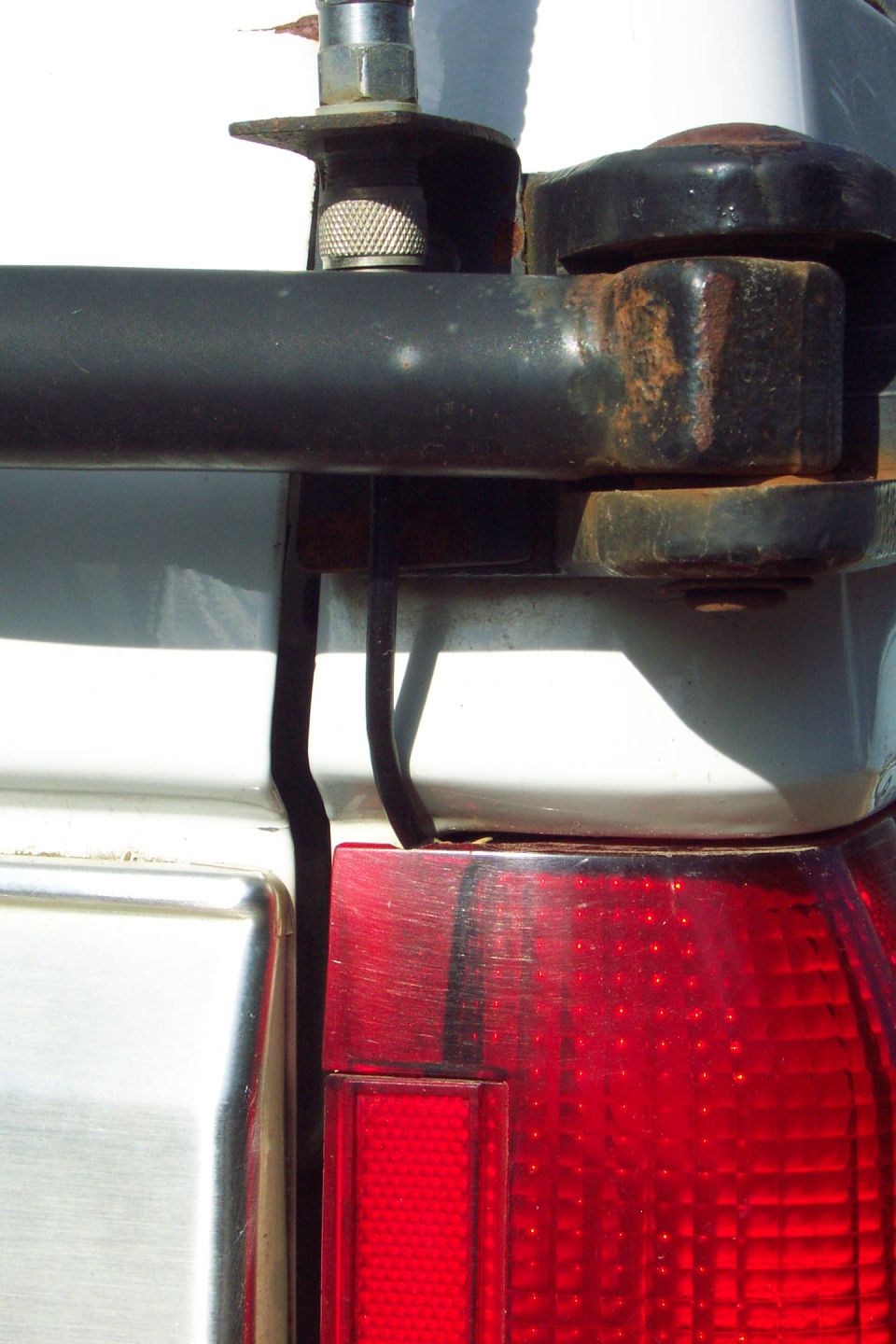 CB Radio Antenna Mount 
Mounted to Tire Carrier Bracket 
(can't depend on the swing arm pin for good ground)
Swing arm in latched position.

Coax routed through tail light.  Used a round file to make a small little notch in top of tail light lens.
(Close-Up)