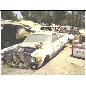 1973 Ford Ranchero - This abandoned pickup truck sits in a junkyard, showing significant wear and tear.