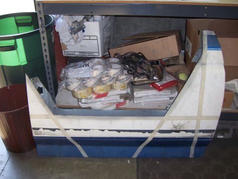 1991 Ford Bronco - A vehicle body panel, likely a fender or door, is shown with blue and white paint and taped sections, stored indoors.
