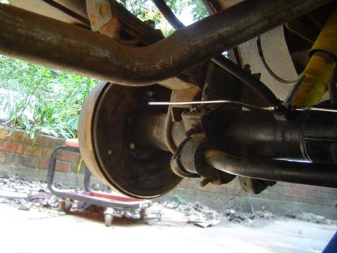 1979 Ford Bronco - Underside view of a vehicle's rear suspension components, including the axle and brake drum.