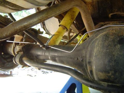 1979 Ford Bronco - Close-up view of the rear axle and suspension system, including leaf springs and a yellow shock absorber.