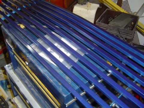 1979 Ford Bronco - Blue metal bars are organized on top of a toolbox in a workshop setting.