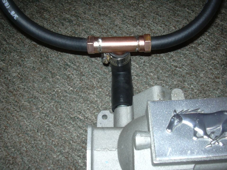 Close-up of a Ford Mustang intake manifold with a copper T-fitting and hose attached