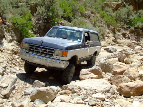 1987 Ford Bronco - This 1987 Ford Bronco navigates a challenging rocky terrain, its off-road capabilities.