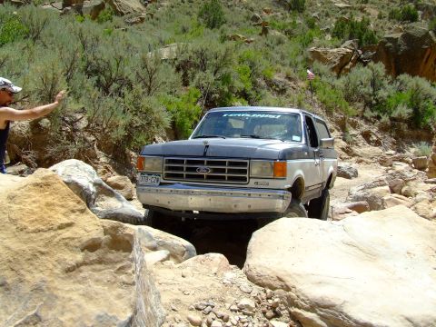 1987 Ford Bronco - This 1987 Ford Bronco tackles a challenging off-road trail with large rocks and steep inclines.