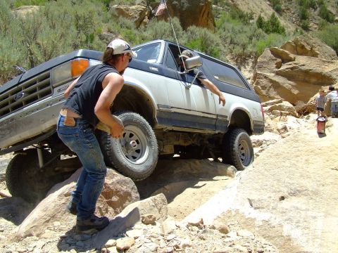 1987 Ford Bronco - A 1987 Ford Bronco tackles a challenging off-road course with assistance from a spotter.