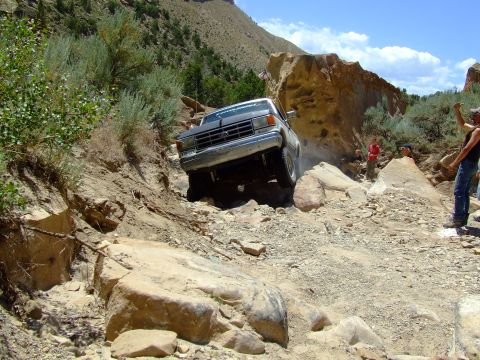 1987 Ford Bronco - Ford Bronco tackling a challenging off-road course on a sunny day.