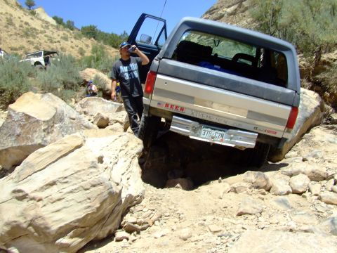 1987 Ford Bronco - A 1987 Ford Bronco is seen off-roading on a challenging rocky path.