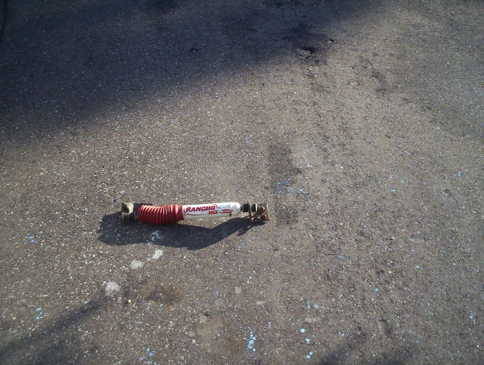 Rancho RSX shock absorber with red bellows on asphalt