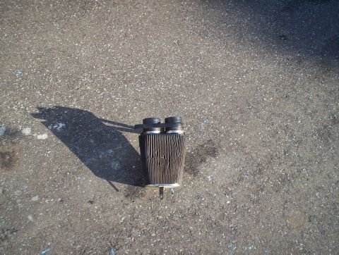 1991 Ford Bronco - Air filter lying on a paved surface, casting a shadow.