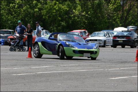 2001 Mercury Grand Marquis - A two-tone Lotus Elise is parked on a track with other vehicles and spectators present.
