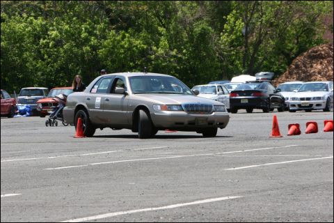 2001 Mercury Grand Marquis - Silver sedan navigates a course marked by orange cones on a paved track.