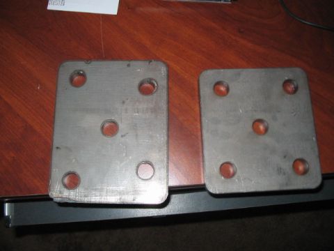 1991 Ford Bronco - Two metal plates with bolt holes are shown on a table.
