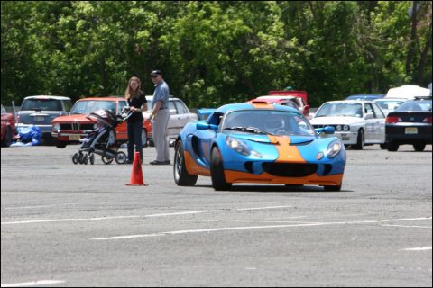 2001 Mercury Grand Marquis - A blue race car with yellow and red stripes navigates a course marked by cones.
