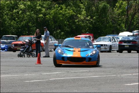 2001 Mercury Grand Marquis - A blue sports car with distinctive orange and yellow stripes on its hood is seen from the front at an event.