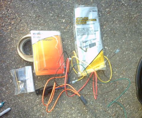 1979 Ford Bronco - A collection of automotive parts, including nylon mounting rods and various wires, laid out on a gravel surface.