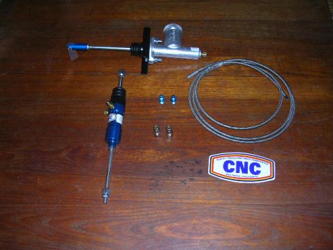 1975 Ford Ranchero - A clutch conversion kit, including master and slave cylinders, braided line, and fittings, is laid out on a wooden surface.