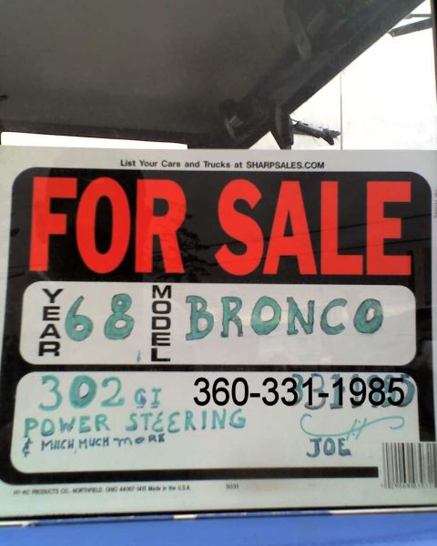 1973 Ford Bronco - Sign advertises a 1968 Bronco for sale, listing features like 302 GT and power steering, with a contact number provided.