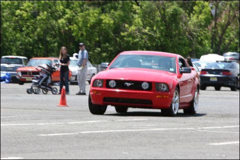 2001 Mercury Grand Marquis - A red Ford Mustang is seen from the front-right at an outdoor event with other vehicles and people present.