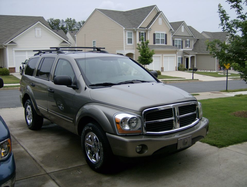Gray 2004 Dodge Durango SUV parked in driveway, front 3/4 view, chrome grille, roof rack