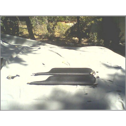 1973 Ford Ranchero - Two black rubber car door seals are placed on a white tarp outdoors.