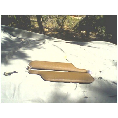 1973 Ford Ranchero - Two tan sun visors are laid out on a tarp, with trees and foliage visible in the background.