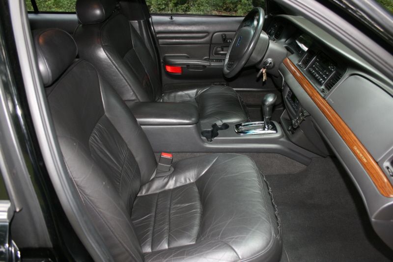 Interior view of a 2002 Ford Crown Victoria showing leather seats, dashboard, and steering wheel