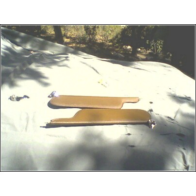 1973 Ford Ranchero - Two tan sun visors are shown on a tarp outdoors.