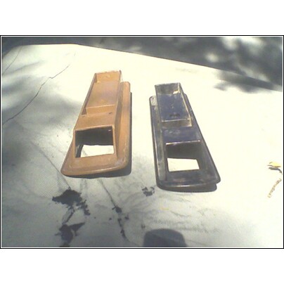 1973 Ford Ranchero - Two plastic vent pieces are shown, one tan and one dark, resting on a textured surface.