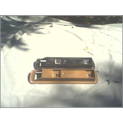 1973 Ford Ranchero - Two car door handles are shown, one black and one tan, placed on a white cloth.