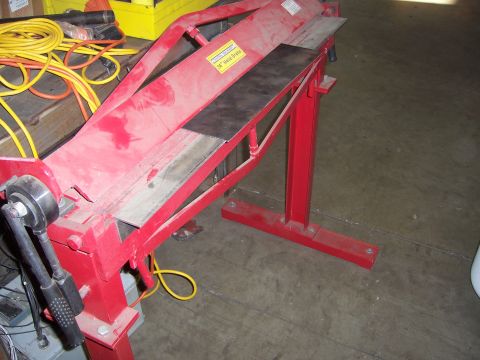 1991 Ford Bronco - A red metal brake machine is shown in a workshop setting with yellow electrical cords nearby.