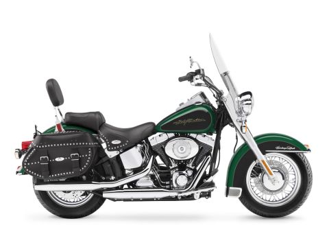 2006 Harley-Davidson Softail - A green 2006 Harley-Davidson Softail motorcycle is shown from the side, studded saddlebags and a clear windshield.