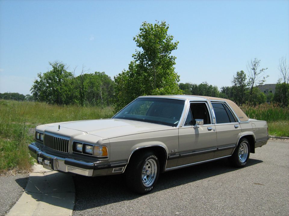 Beige Mercury Grand Marquis sedan parked near grass and trees
