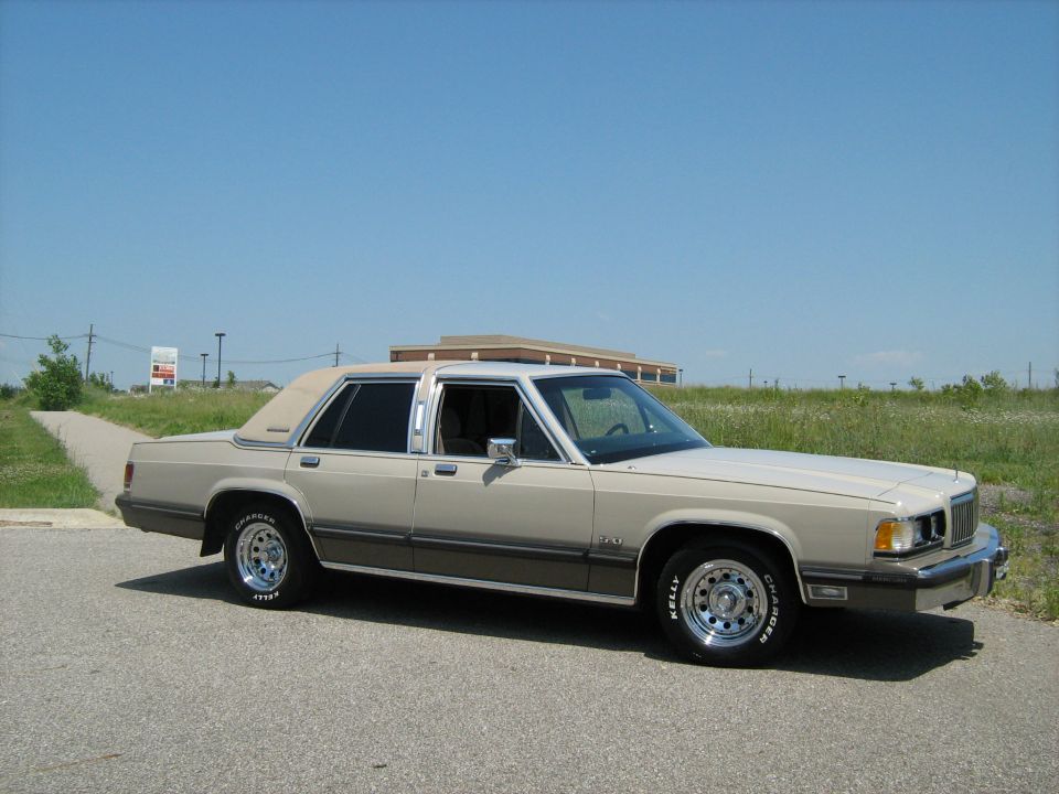 Beige two-tone Mercury sedan in profile in a field