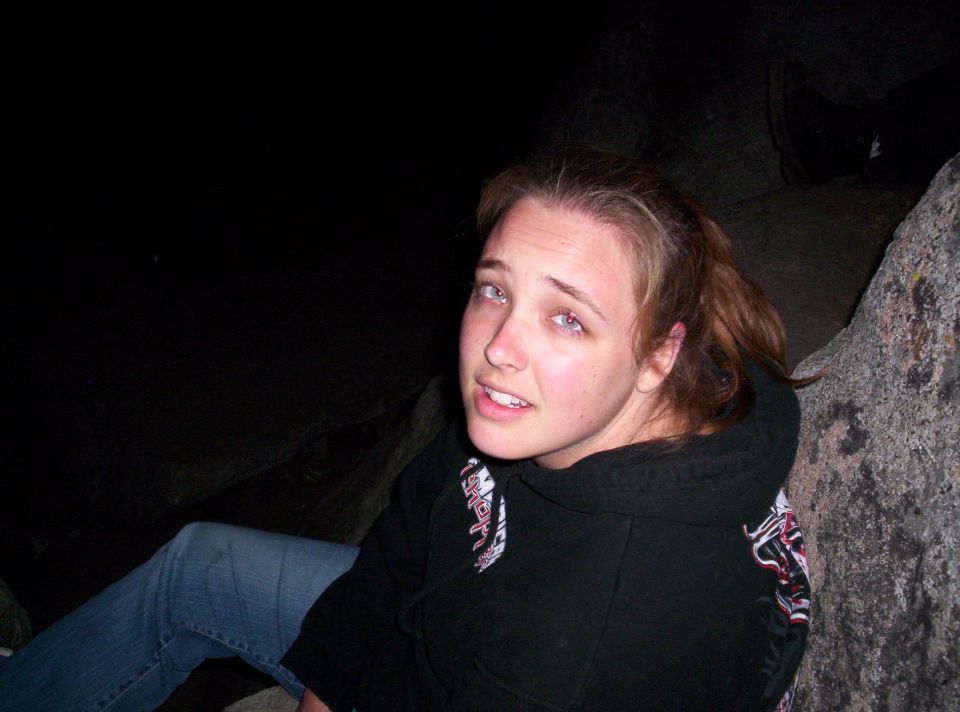 Woman sitting on rocks in the dark