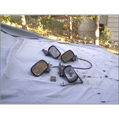 1973 Ford Ranchero - Several car side mirrors are laid out on a tarp, with some showing signs of age and wear.