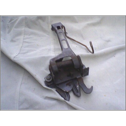 1973 Ford Ranchero - A close-up view of a vehicle's hood latch mechanism, presented on a white cloth surface.