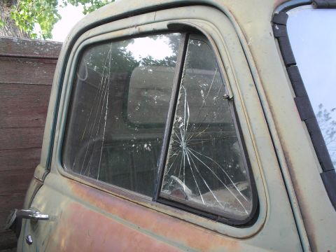 1951 Chevrolet C/K Pickup - The rear window of a 1951 Chevrolet C/K Pickup shows extensive damage, with spiderweb cracks radiating from a central impact point.