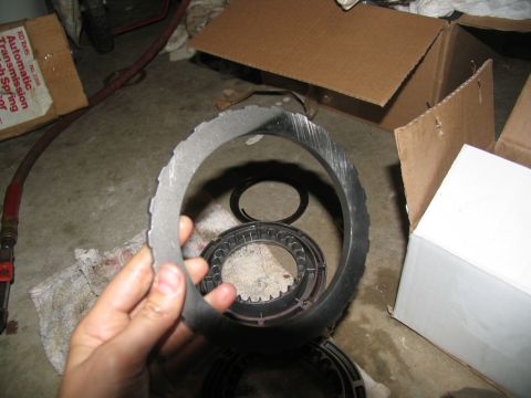 1978 Ford Bronco - Worn transmission clutch plate being held up for inspection, with other transmission components visible.