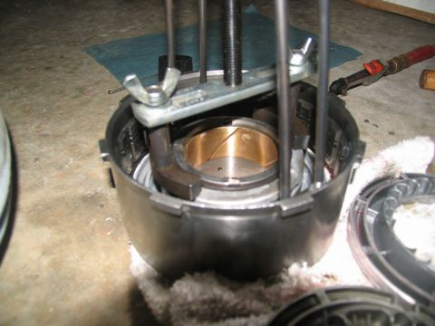 1978 Ford Bronco - A mechanic uses a specialized tool to disassemble a transmission drum, revealing internal components.