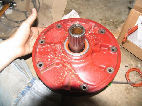 1978 Ford Bronco - A red transmission part with a splined shaft is held by a hand, with tools and a box in the background.