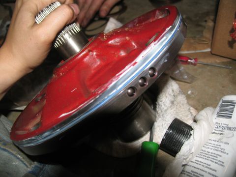 1978 Ford Bronco - Close-up of a transmission torque converter part during assembly, showing red coating and ball bearings.