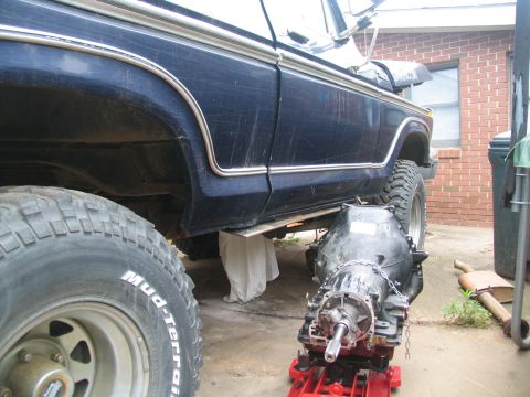 1978 Ford Bronco - Transmission removed from a 1978 Ford Bronco for rebuild, showing the vehicle's side and undercarriage.
