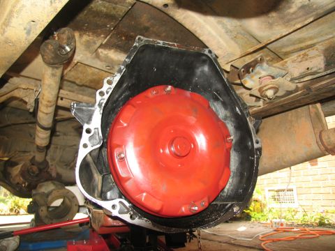 1978 Ford Bronco - Close-up of a red transmission torque converter being worked on, likely during a rebuild or installation.