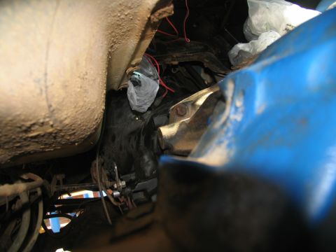1978 Ford Bronco - Underside view of vehicle transmission and surrounding frame, with a blue body panel visible.