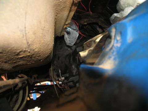 1978 Ford Bronco - Undercarriage view of vehicle transmission components, with some wiring and a protective bag.