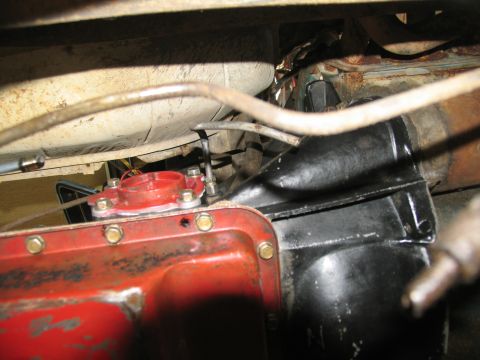 1978 Ford Bronco - Underside view of vehicle transmission components, showing a red part bolted to a larger black housing.