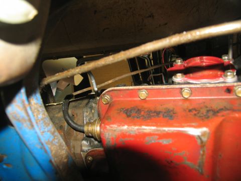 1978 Ford Bronco - Close-up view of vehicle transmission and engine components, showing a red pan and various metal parts.