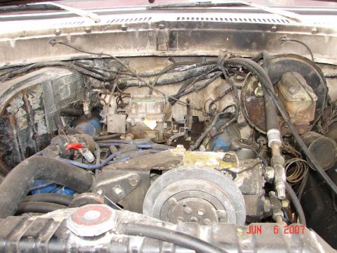 1978 Ford Bronco - Engine bay of a 1978 Ford Bronco, showing the carburetor and various hoses.