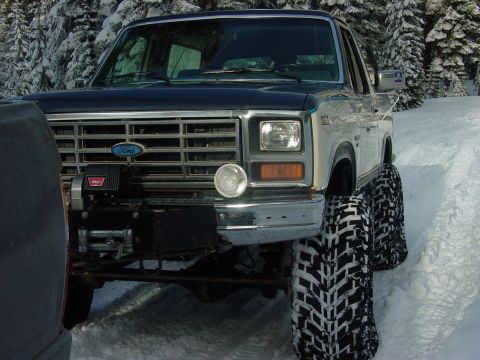 1986 Ford Bronco - This 1986 Ford Bronco is equipped with a winch and large off-road tires, ready for snowy conditions.
